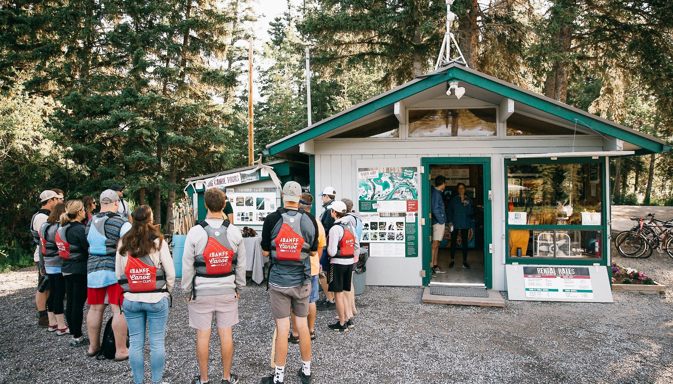 People listening to a tour guide giving an interpretive talk at the Banff Canoe Club before a Big Canoe Tour