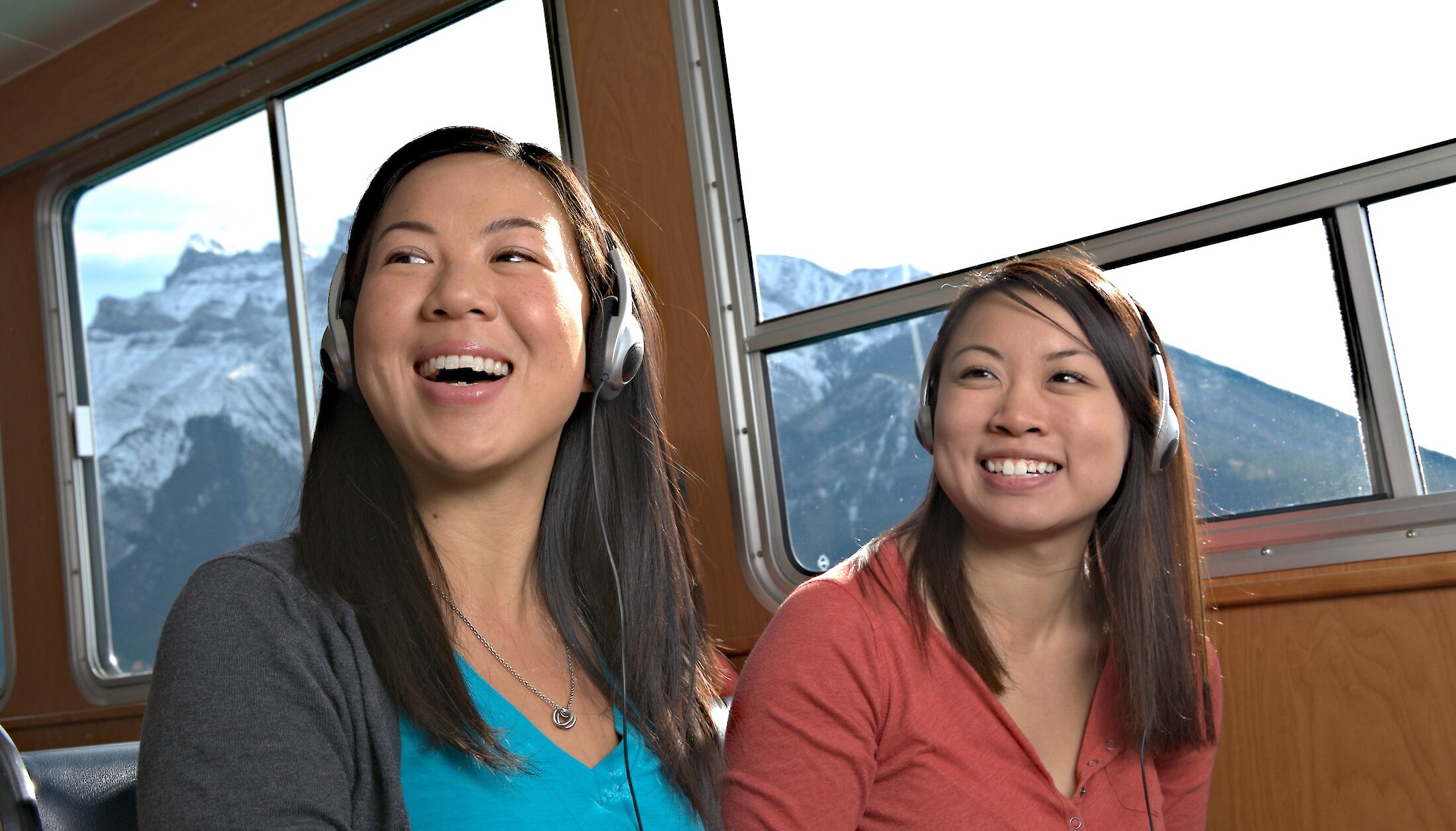 Two people enjoying some audio on the lake cruise on lake minnewanka in Banff