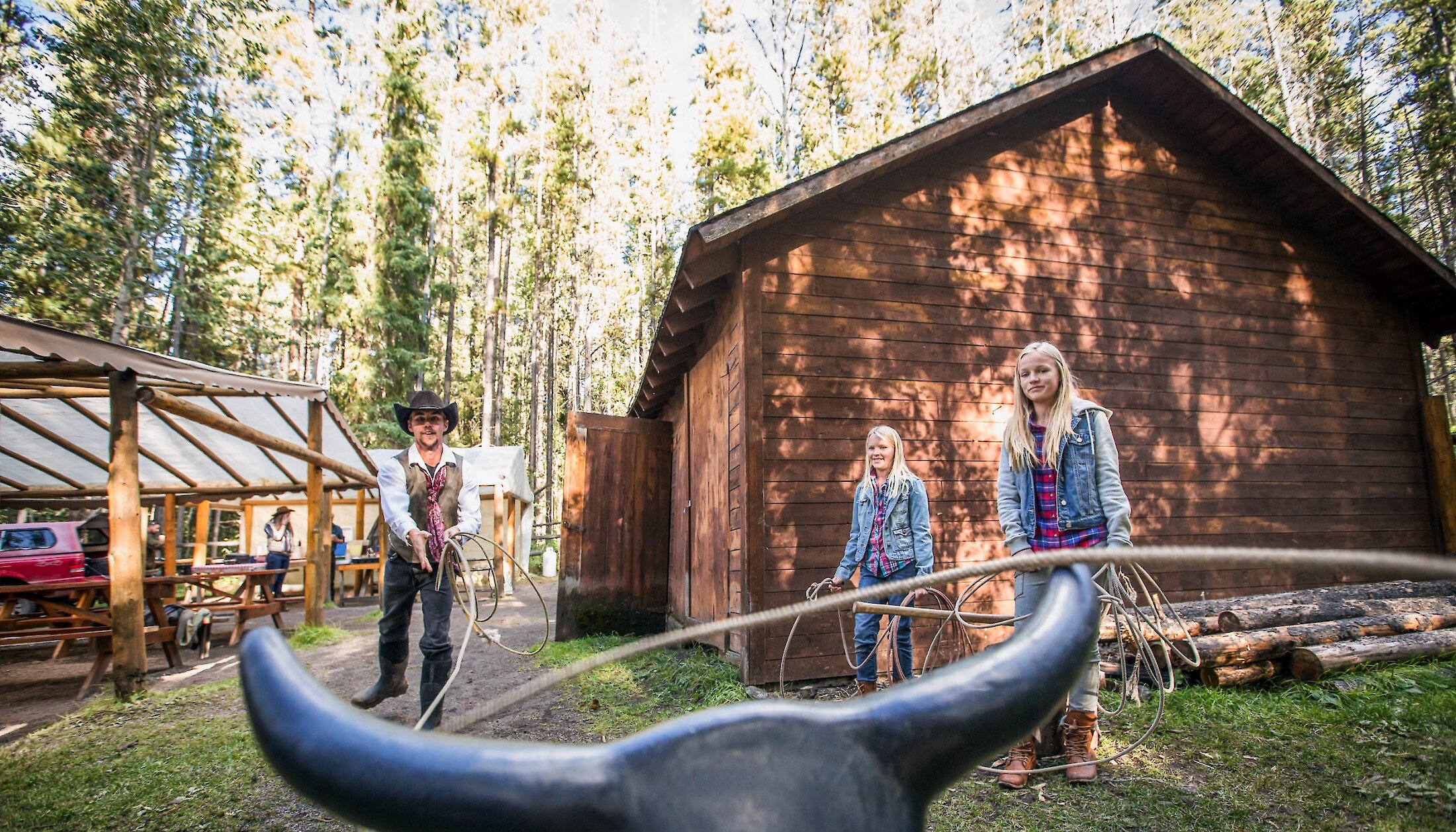 People lassoing with a cowboy at the cowboy cookout in Banff