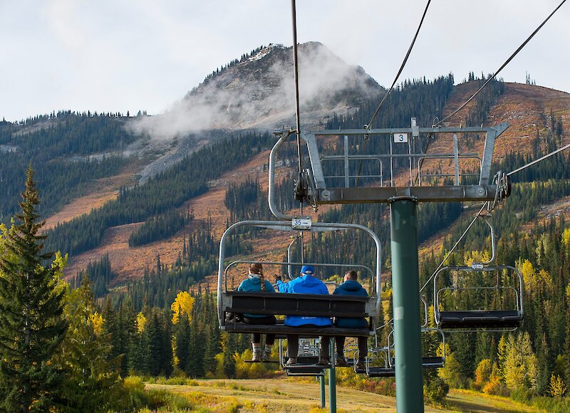 People on a chairlift at Kicking Horse Mountain Resort admiring the mountain views
