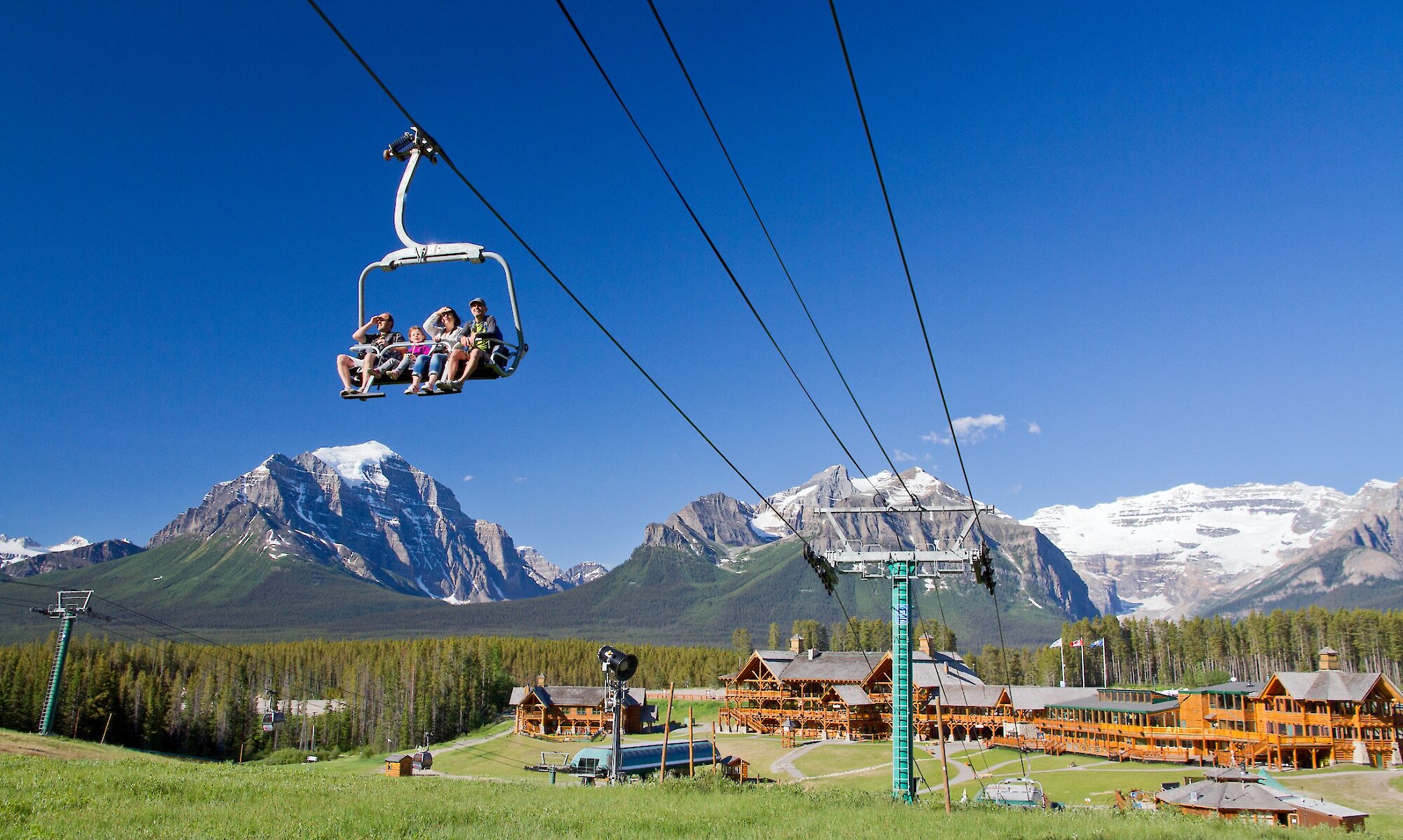 The Lake Louise sightseeing chairlift on a bluebird day with mountains in the background