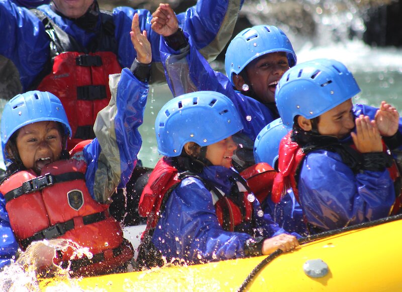 Kids getting wet on a rafting trip on Kananaskis River