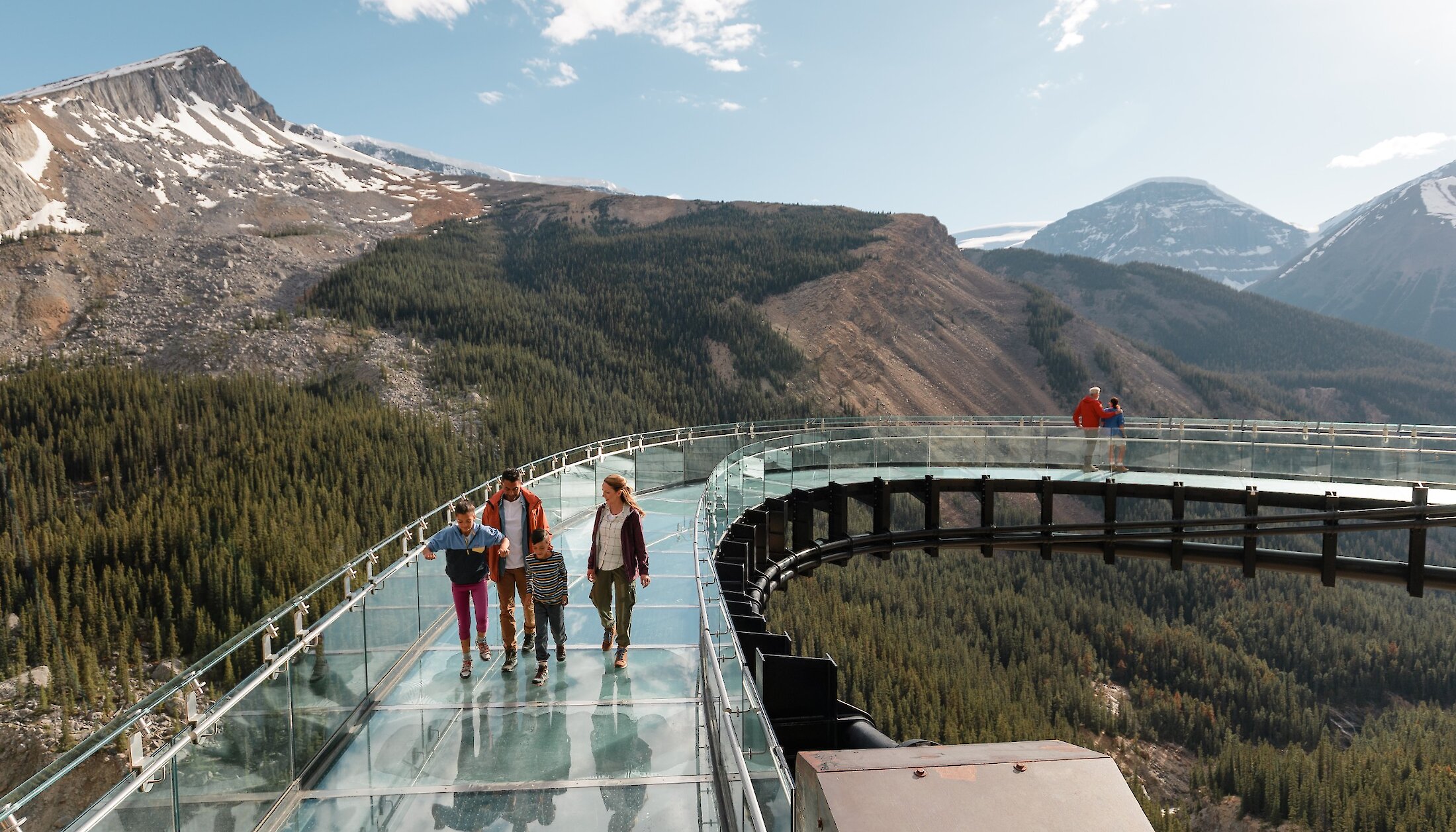 A family on the glass bottom skybridge at the Columbia Icefield Adventure Centre