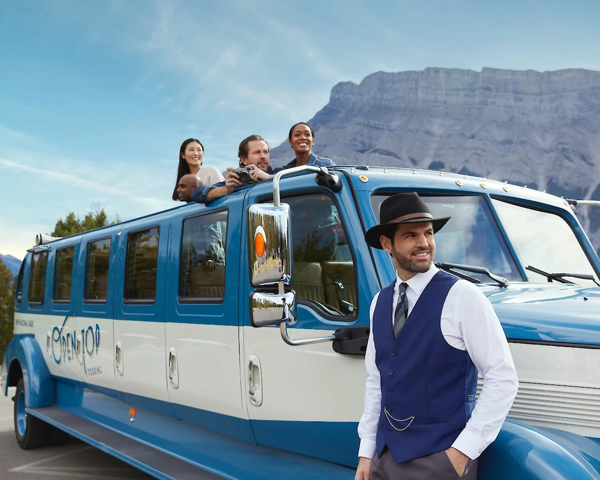 Guide and guests on open top tour in Banff