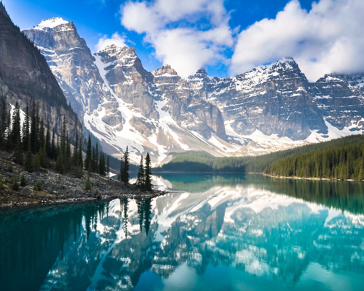 Moraine lake on a beautiful sunny day with the mountains reflecting in the water