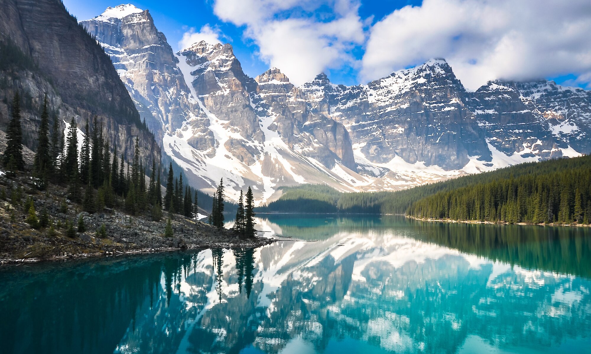 Moraine lake on a beautiful sunny day with the mountains reflecting in the water