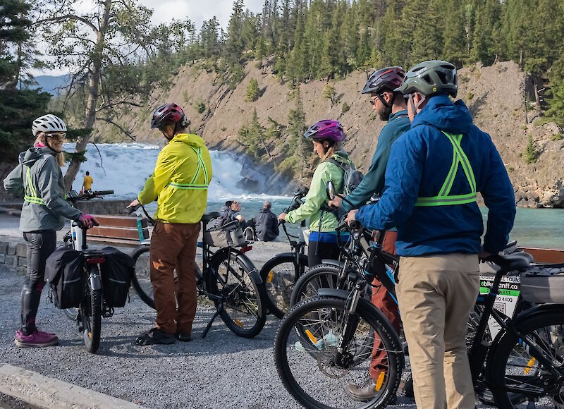 People talking to a guide at the Bow Falls on an Ebike tour in Banff