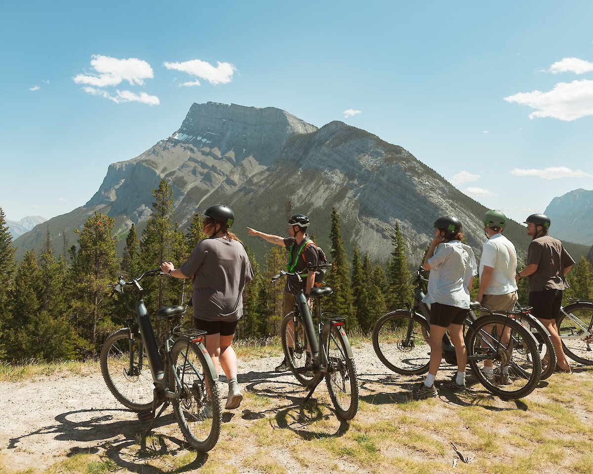 A guide describing the view to guests from Tunnel Mountain on a guided e-bike tour