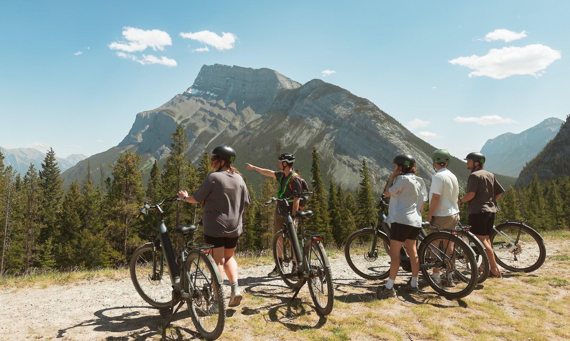 A guide describing the view to guests from Tunnel Mountain on a guided e-bike tour