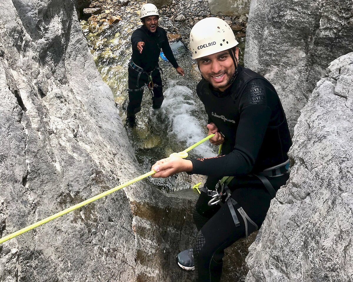 Two people in heart canyon holding onto a rope