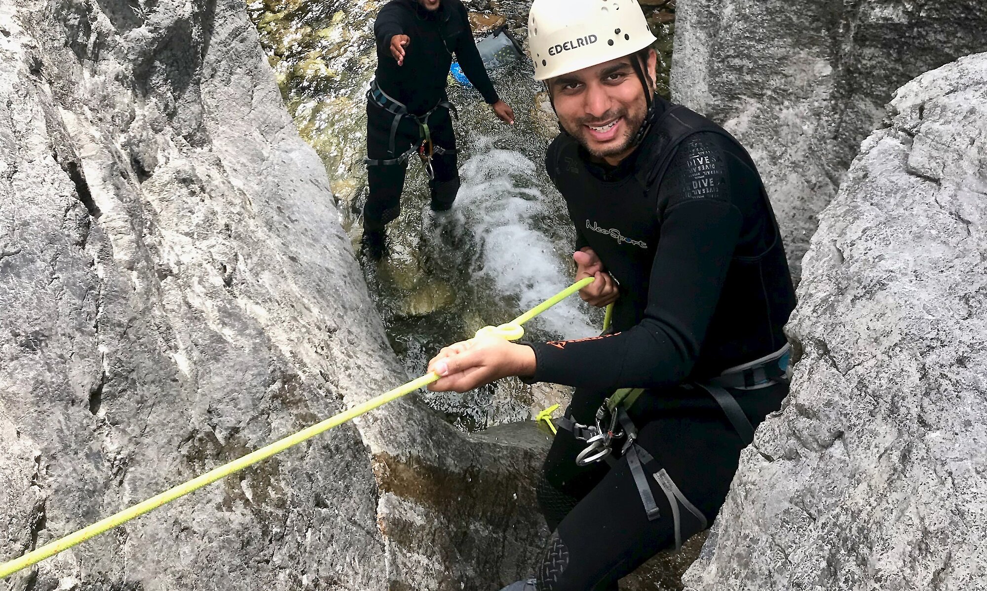 Two people in heart canyon holding onto a rope