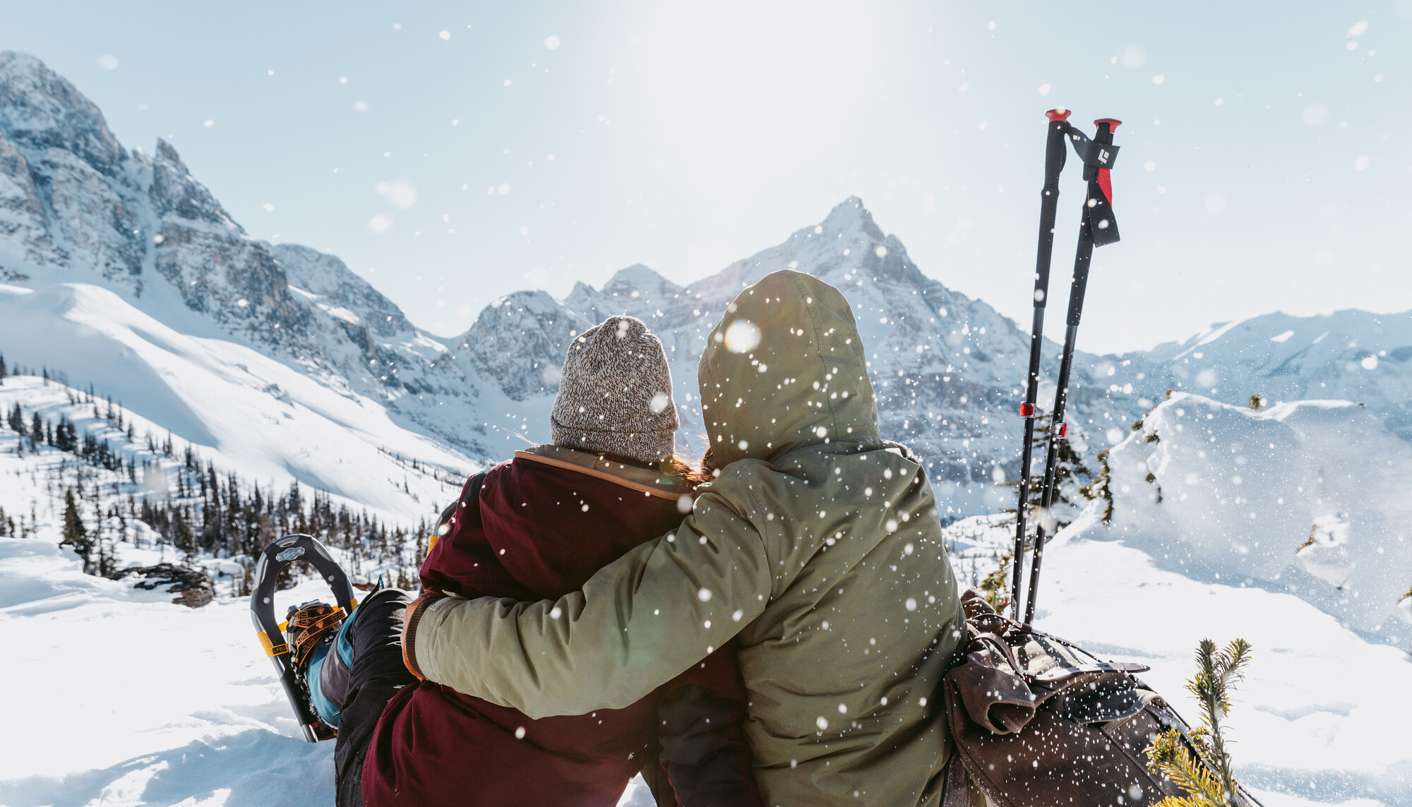 Couple sitting and admiring the view whilst snowshoeing in Banff