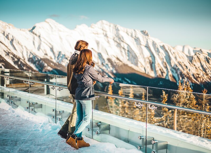 Couple admiring the view from the top of the Banff Gondola in winter